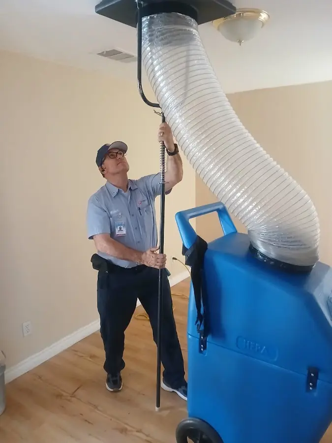 Furnace Tune-Up technician using HEPA equipment in Elsa